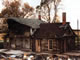 Demolition, showing original 1-room log home at center of structure
